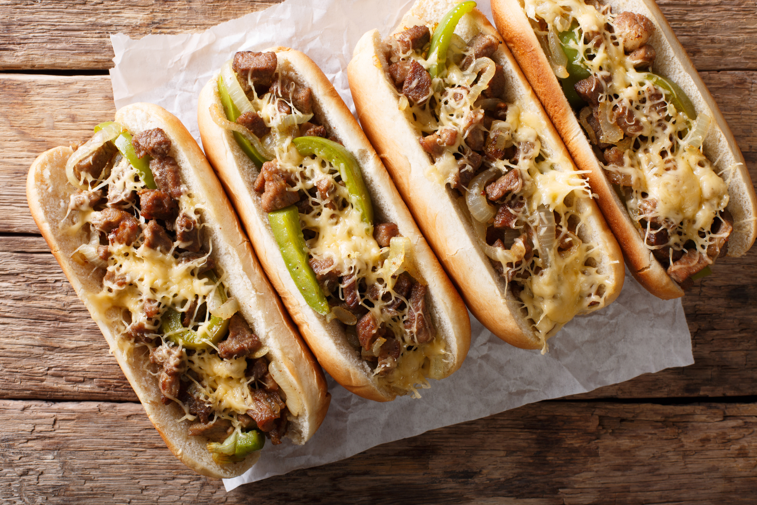 Philly cheese steak sandwich served on parchment paper close-up. horizontal top view